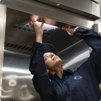 a1_services-header-3254_featured-mobile 1 A-1 Services Group technician inspecting the underside of a commercial kitchen exhaust hood