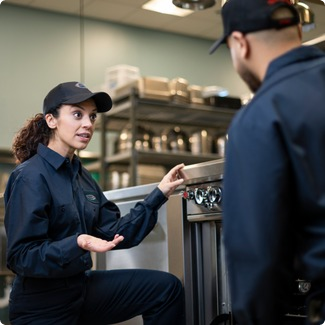 A-1 Services Group technician walking a colleague through equipment training in a commercial kitchen