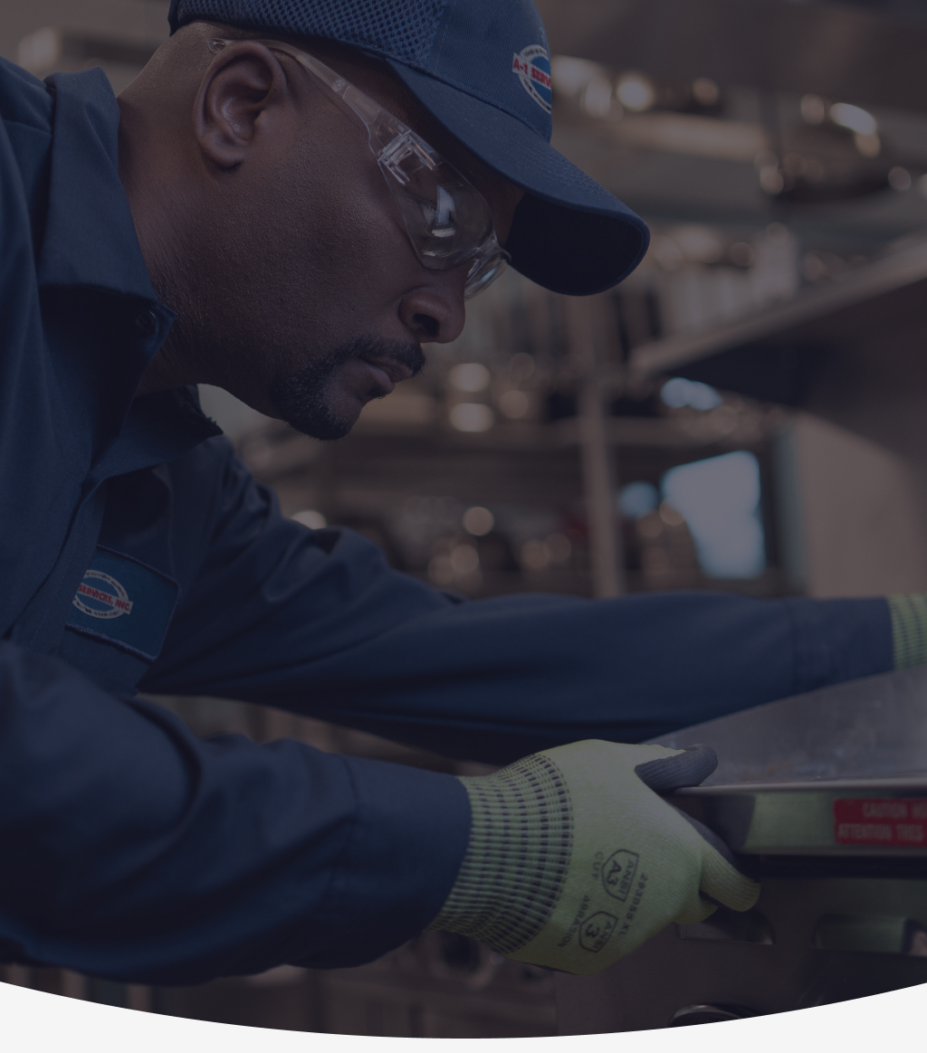 A-1 Services Group technician in safety glasses servicing a commercial cooking appliance